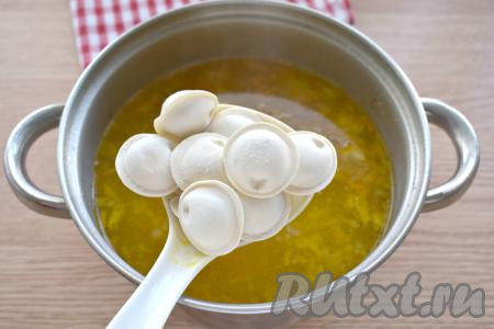 Затем в куриный суп выкладываем пельмени, даём закипеть супу на достаточно сильном огне, убавляем огонь и с момента всплытия пельмешек варим 5-6 минут.