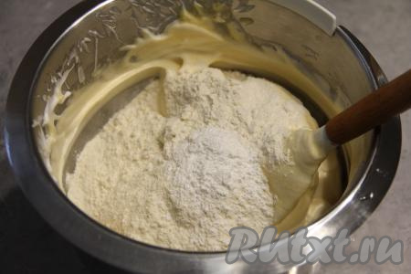 Влить молоко и растопленное сливочное масло в смесь белков и желтков, перемешать лопаткой. Масса должна остаться воздушной. Всыпать просеянную муку и разрыхлитель, аккуратно вмешать в бисквитное тесто.