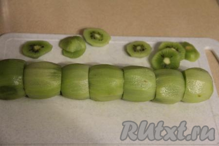 Киви почистить. Отрезать кончики каждого киви с двух сторон. Каждый киви будет напоминать бочонок. Сформировать вот такую змейку.