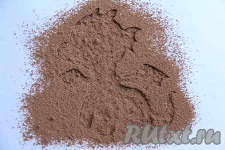 Через сито присыпать трафарет какао.