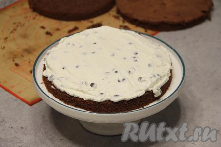 Для приготовления пропитки соединить воду и сироп тщательно перемешать. Теперь приступаем к сборке торта. Для этого на плоскую тарелку или тортницу выложить первую часть бисквита, пропитать его частью получившейся пропитки. Выложить часть крема и равномерно распределить.