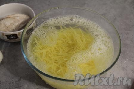 Картошку почистить и натереть на тёрке для моркови по-корейски. Промыть картошку несколько раз холодной водой, затем залить ещё раз водой и оставить на 20 минут.