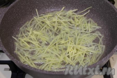 В сковороду влить растительное масло и хорошо разогреть. Выложить часть подготовленной картошки на сковороду. Выкладывать нужно тонким слоем, чтобы картофель получился аппетитным, хорошо прожаренным.