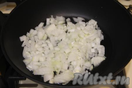 Теперь приготовим начинку. Для этого в сковороде нужно хорошо прогреть растительное масло, огонь уменьшить до среднего, выложить мелко нарезанный лук, обжарить его до прозрачности (на это потребуется минут 5), периодически перемешивая.