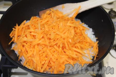 Натереть на крупной тёрке обе морковки и выложить к обжаренному луку, перемешать овощи.