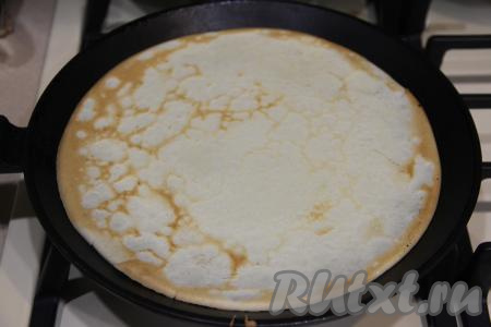 Хорошо разогреть сковороду (я взяла сковороду диаметром 22 сантиметров). В состав теста входит растительное масло, поэтому сковородку даже перед выпечкой первого блина можно маслом не смазывать или смазывать несильно. Тут всё зависит от качества вашей блинной сковороды. Я сковороду маслом не смазывала. Влить на сковородку половник теста и жарить блин на среднем огне до подрумянивания с двух сторон. Затем получившийся не тонкий блинчик переложить на тарелку. Постепенно пожарить все блины, периодически перемешивая тесто. Из указанного количества ингредиентов у меня получилось 7 блинов. 