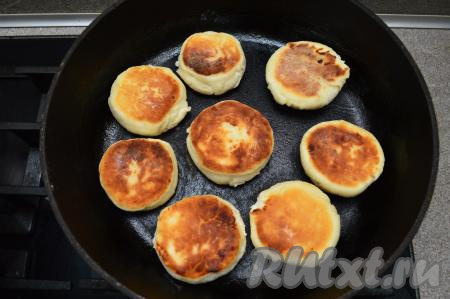 Затем перевернуть сырники, сковороду накрыть крышкой, чуть уменьшить огонь и продолжить жарить до подрумянивания с другой стороны (ориентировочно 2-3 минуты). Затем сырники, обжаренные с двух сторон, снова перевернуть, накрыть крышкой, выключить огонь и оставить пропариться под крышкой в течение 5 минут.