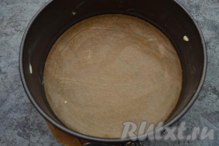 Пока манка набухает, сразу поставить духовку на разогрев, выставив температуру 180 градусов. Дно формы для запекания (я взяла форму диаметром 16 сантиметров) застелить пекарской бумагой. Бока и дно формы, застеленное бумагой, смазать небольшим кусочком сливочного масла. Смазывать маслом форму нужно для того, чтобы запеканка не приставала ко дну и стенкам формы при выпечке.