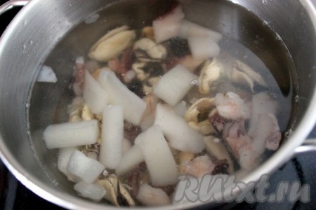 В кипящую воду положите морепродукты.