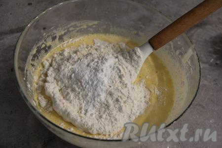 Всыпать соль, разрыхлитель, ванилин и половину муки, перемешать лопаткой.