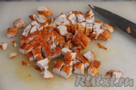 Часть жареной курицы отложить в сторону для подачи. А оставшееся мясо нарезать на кубики.