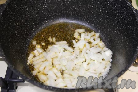 Переложить жареные кусочки курицы на тарелку. Лук почистить, мелко нарезать и выложить в кастрюлю, в которой обжаривалось мясо. Обжарить лук до прозрачности (в течение 3-4 минут) на среднем огне, иногда помешивая.