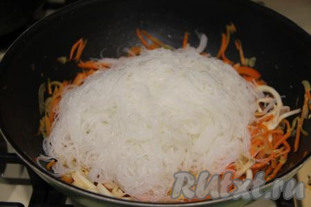 Затем добавить фунчозу, влить соевый соус.