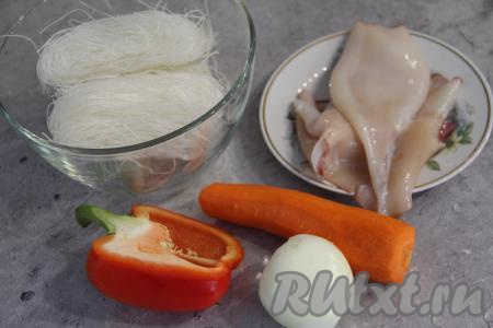 Подготовить продукты для приготовления фунчозы с кальмарами и овощами. Тушки кальмаров полностью разморозить при комнатной температуре. Если кальмары не чищенные, тогда их нужно очистить от тёмной плёночки, покрывающей их поверхность и от хорды, находящейся внутри тушек. Лук, чеснок и морковь почистить. Удалить семена и плодоножку из половинки болгарского перца.