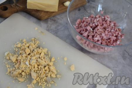 Колбасу нарезать на мелкие кубики. Разделить варёные яйца на белки и желтки. Раскрошить желтки.