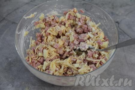 Перемешать салат из колбасы, сыра, яиц и яблока.