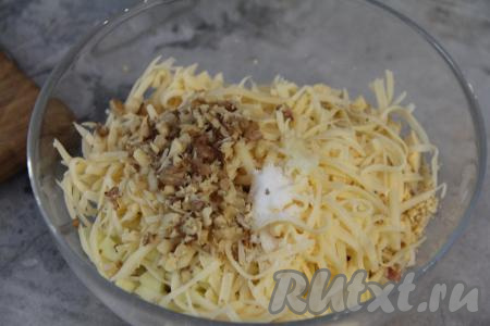 Чеснок почистить и пропустить через пресс. Грецкие орехи порубить ножом. Выложить в салатник сыр, чеснок и орехи. Подсолить содержимое салатника по вкусу.