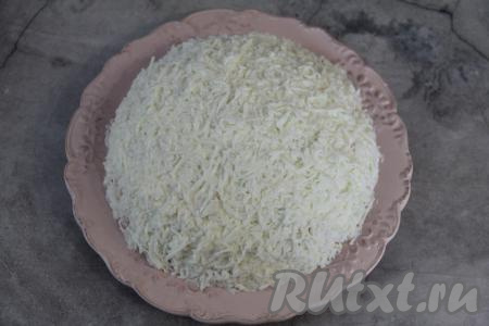 Белки натереть на мелкой тёрке. Аккуратно покрыть салат натёртыми белками.