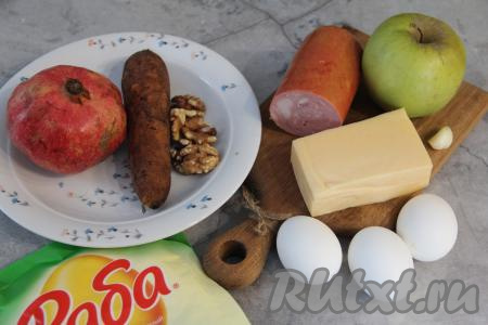 Подготовить продукты для приготовления салата "Новогодний шар". Яйца предварительно сварить вкрутую (варить 10 минут с момента закипания воды). Морковку сварить в кожуре до готовности (в течение 30 минут с момента начала кипения воды). Варёные яйца и морковь остудить и очистить. Яблоко помыть. Зубчик чеснока очистить.