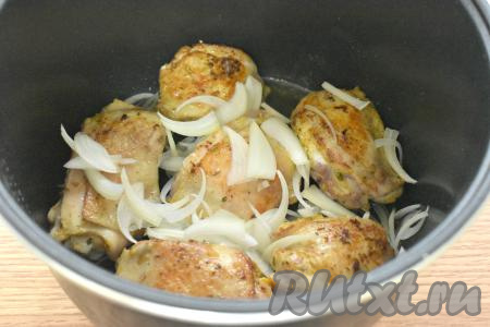 К жареным куриным бёдрам добавляем очищенный лук, нарезанный на четверть кольца (или полукольца), аккуратно перемешиваем и обжариваем 5 минут.