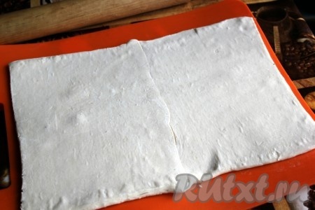 Тесто разморозьте, сложите пласты в нахлёст, скрепите и немного раскатайте.