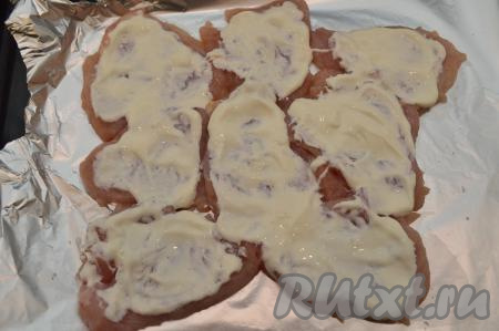 Смазать отбивные сверху сметаной или майонезом.