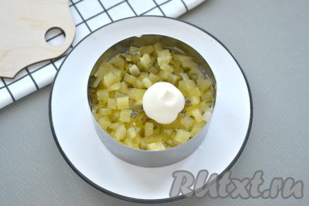 Нарезаем мелко маринованный огурец. 1/3 огурцов выкладываем равномерно поверх яиц, смазываем слегка майонезом.