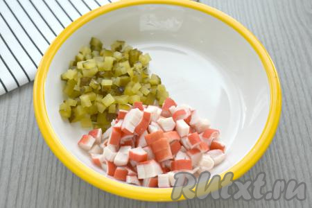 Маринованный огурец нарезаем на кубики такого же размера, как нарезаны крабовые палочки, и добавляем в миску.