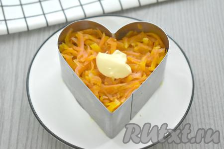 Следующим слоем выкладываем натёртую на крупной тёрке морковь. Смазываем морковный слой майонезом.