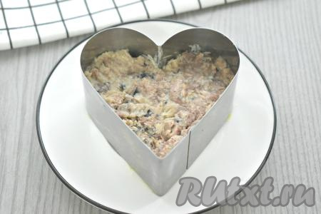 Открываем баночку рыбных консервов. Кусочки рыбы достаём и перекладываем на отдельную тарелку, разминаем вилкой рыбу, удаляя, если есть, крупные косточки. В формы поверх лука ровным слоем раскладываем размятые рыбные консервы, покрывать этот слой майонезом не нужно.