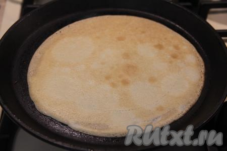 Хорошо разогреть сковороду (я взяла сковородку диаметром 20 сантиметров) на достаточно сильном огне, смазать немного растительным маслом. На раскалившуюся сковороду влить половник теста, распределить равномерно по дну и жарить блин на среднем огне до подрумянивания с двух сторон, а затем переложить на тарелку. Постепенно пожарить все блины (у меня вышло 18 штук), складывая их стопкой на тарелку. Так как в блинное тесто входит растительное масло, то сковороду можно смазывать маслом только по мере необходимости, но тут ещё всё зависит от качества антипригарного покрытия вашей сковороды. По мере выпечки блинов нужно периодически перешивать блинное тесто в миске, чтобы оно не застаивалось.