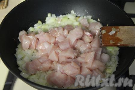 Разогреть растительное масло в сковороде, выложить нарезанный лук и обжарить его на среднем огне в течение 5 минут, иногда помешивая. Затем добавить кусочки куриного филе, перемешать и обжаривать минут 10, периодически перемешивая.