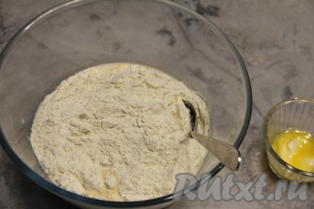 Всыпать муку и перемешать тесто ложкой. Сливочное масло растопить (до жидкого состояния его можно не растапливать), дать ему немного остыть.