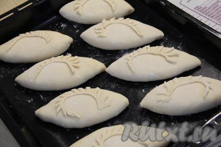 Выложить пирожок швом вниз на противень, предварительно застеленный тефлоновым ковриком (или пергаментом). Аналогично сформировать и выложить на расстоянии друг от друга все 8 пирожков. Из теста, которое я оставляла для украшения, я вырезала веточки и выложила на пирожки. Оставить пирожки для расстойки на 15 минут на кухонном столе.