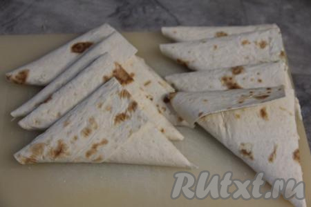 Сделать несколько оборотов треугольником. У нас получится плотный треугольный конвертик из лаваша с начинкой внутри.