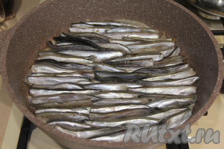 На сковороду поверх луковой подушки выложить плотно друг к другу мойву в один слой.