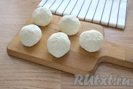 Творожное тесто делим на 5 кусочков. Из каждого кусочка формируем округлый сырник. Желательно формировать сырники влажными руками, тогда они лучше обваливаются в муке, а творожное тесто меньше прилипает к рукам.