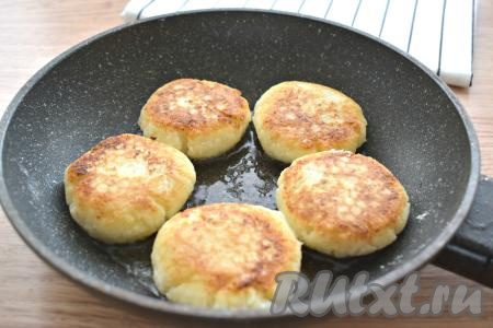 Вливаем на сковороду растительное масло и разогреваем его. Выкладываем заготовки сырников в масло, стряхнув с них лишнюю муку. На умеренном огне жарим сырники примерно по 3 минуты с каждой стороны. Сырники должны покрыться аппетитной золотистой корочкой с двух сторон.