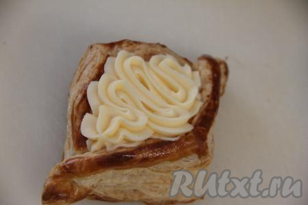 Отсадить крем из кулинарного мешка, не жалея, в углубление в каждой слойке. Если нет кулинарного мешка, можно наполнить слойки заварным кремом с помощью столовой ложки.