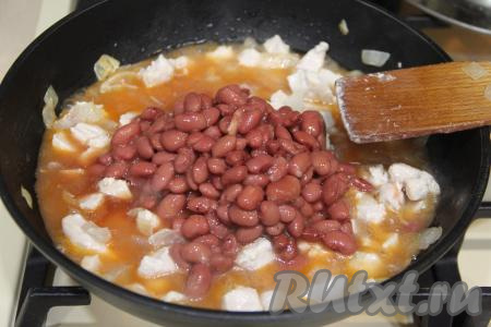 Добавить в сковороду консервированную фасоль вместе с жидкостью.