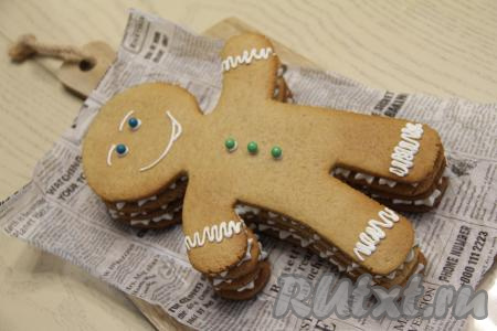 Украсить торт кремом, нарисовав лицо человечку и украшения на ножках и ручках, а глазки и пуговки сделать, например, из конфет по типу M&M's.