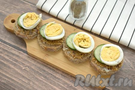 Яйцо нарезаем на кружочки и выкладываем поверх огурца. Яйцо можно немного поперчить.