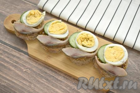 Филе солёной сельди нарезаем на кусочки, убираем косточки, если они есть. На свободную сторону бутерброда выкладываем по кусочку селёдки.