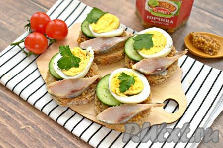 Бутерброды с селёдкой и зернистой горчицей украшаем веточками свежей зелени (у меня - петрушка) и сразу подаём к повседневному или праздничному столу. Эти бутербродики готовятся и просто, и достаточно быстро, а получаются сытными, очень вкусными и аппетитными.