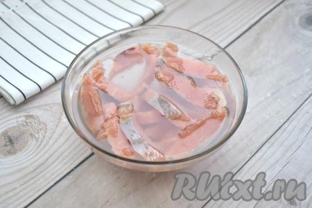 Складываем кусочки горбуши в миску и заливаем остывшим соляным раствором. Выдерживаем так рыбу в растворе 30 минут при комнатной температуре.