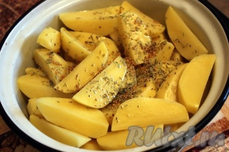 Картофель очистите, нарежьте крупными дольками, посыпьте розмарином и зерновой горчицей, посолите и сбрызните оливковым маслом.