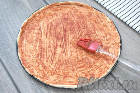 Основу для пиццы из слоёного теста смазываем томатной пастой (вместо пасты можно взять кетчуп или томатный соус).