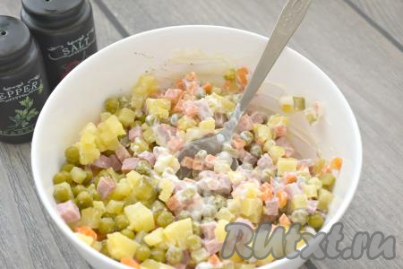 Перемешиваем салат Оливье, приготовленный без яиц, перчим его и солим.