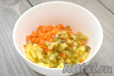 Сюда же выкладываем маринованный (или солёный) огурец, нарезанный на маленькие кубики.