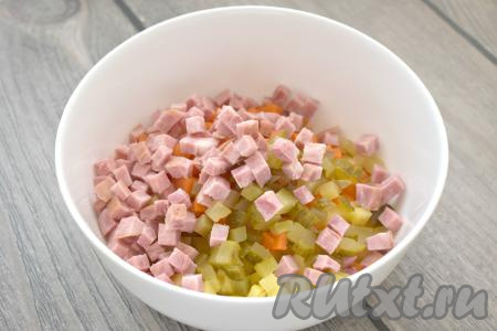 Варёную колбасу (или ветчину) тоже нарезаем на маленькие кубики, добавляем в салат. Старайтесь, чтобы все овощи и колбаса были нарезаны на кубики одинакового размера, тогда "Оливье" получится особенно вкусным.